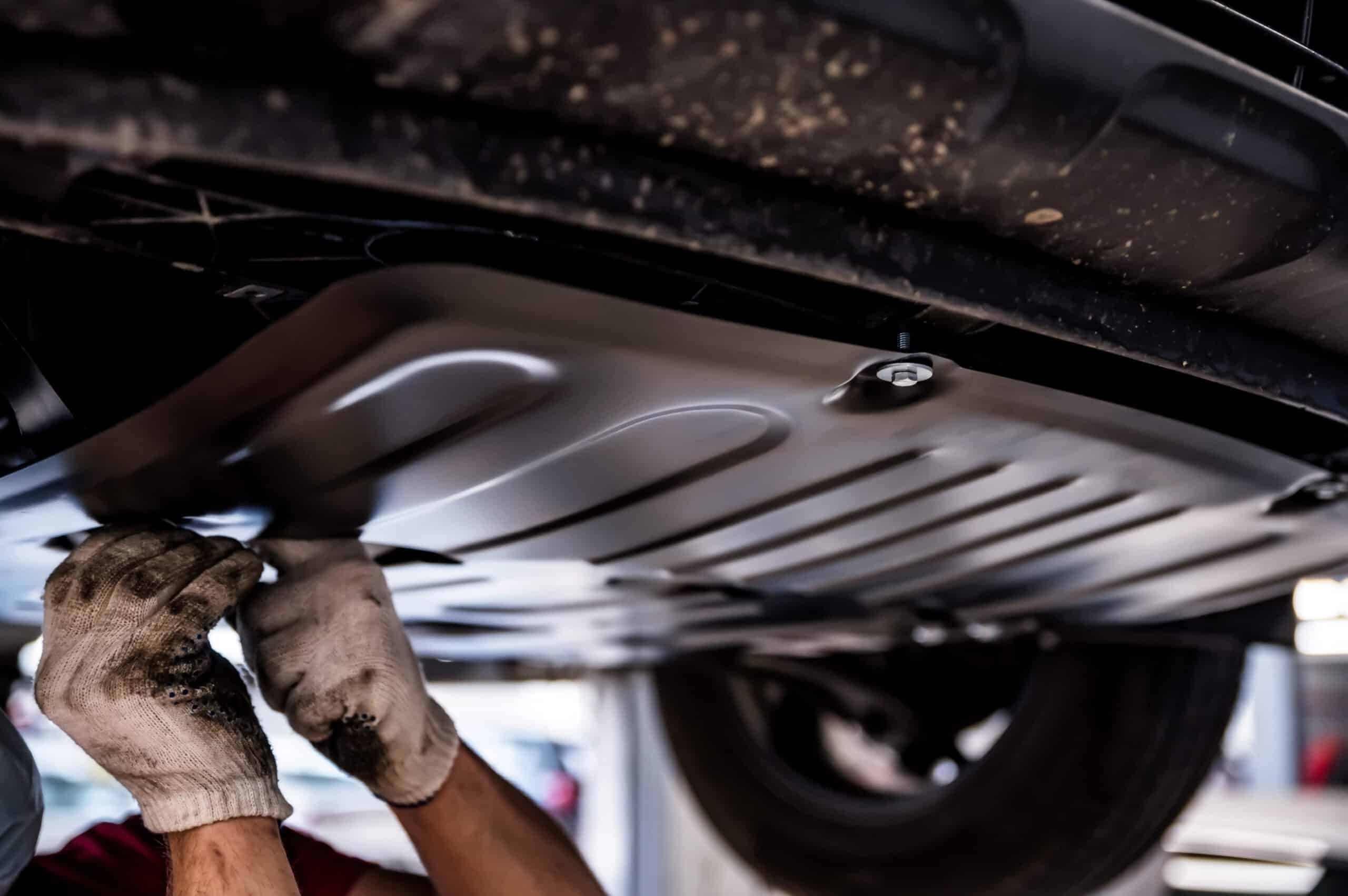 Car Undercoatings to Protect Your Vehicle Mechanic installs underbody protection on a car raised on car lift