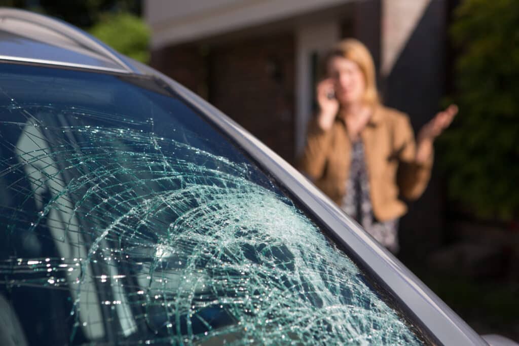 Woman Phoning For Help After Car Windshield Has Broken. Crack a Windshield